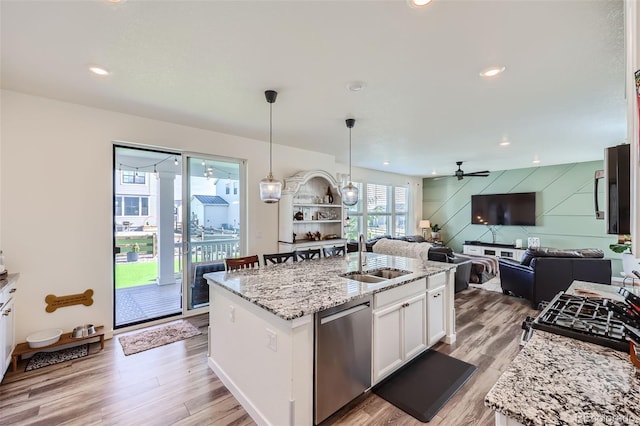 kitchen with dishwasher, white cabinetry, sink, a kitchen island with sink, and light stone countertops