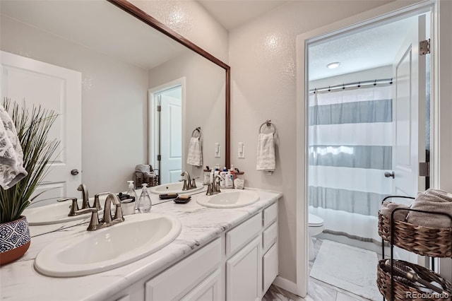 bathroom featuring walk in shower, vanity, and toilet