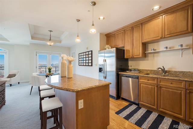 1827 N Grant St Unit 1104, Denver, CO 80203 - kitchen featuring stainless steel appliances, a tray ceiling, a kitchen breakfast bar, brown cabinets, and recessed lighting