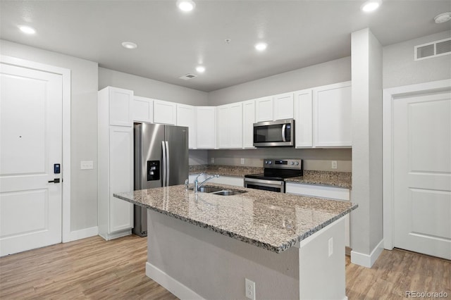kitchen with stainless steel appliances, a sink, baseboards, light wood-type flooring, and recessed lighting