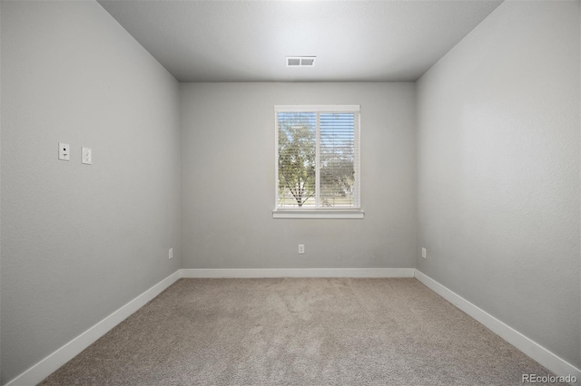 empty room featuring light colored carpet and baseboards