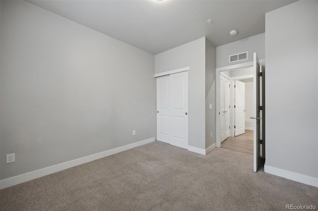 unfurnished bedroom with carpet, baseboards, and a closet