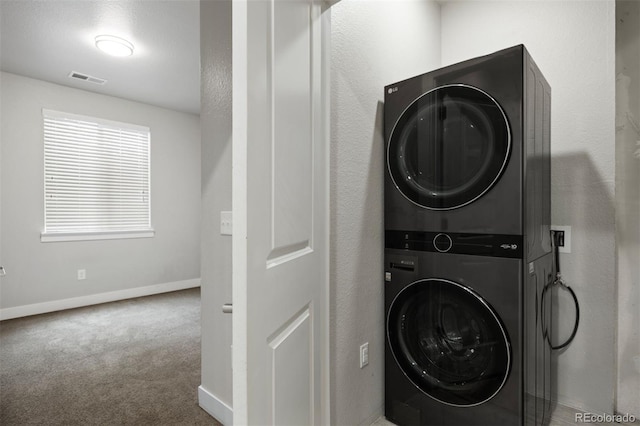 washroom featuring estacked washer and dryer, baseboards, and carpet floors