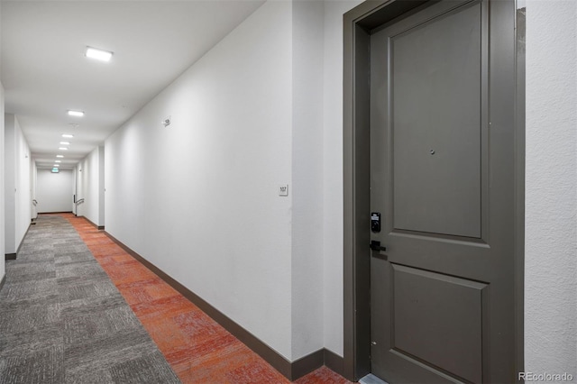hallway with light wood-type flooring and baseboards