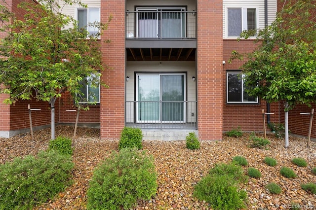 view of home's exterior featuring a balcony and brick siding