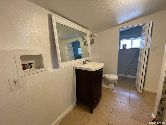 bathroom featuring tile patterned flooring, a textured ceiling, vanity, and toilet