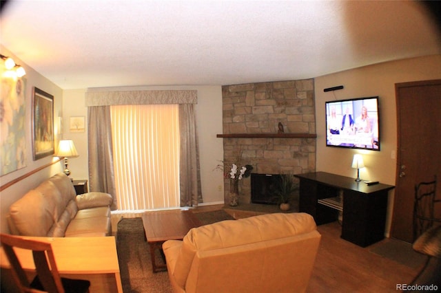 living room with a stone fireplace and hardwood / wood-style flooring