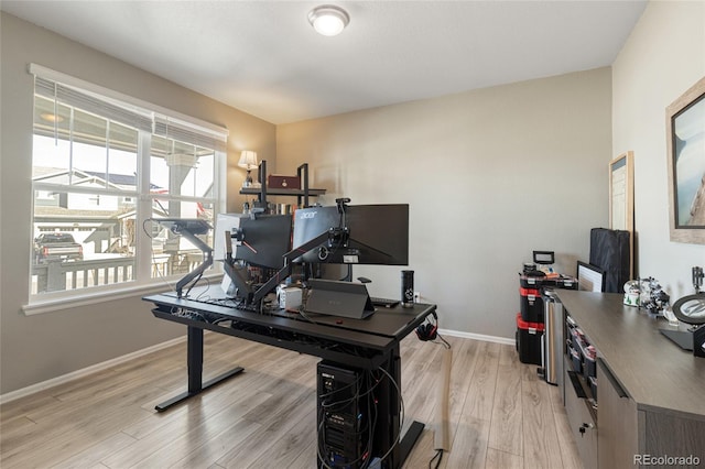 office area with baseboards and light wood-type flooring