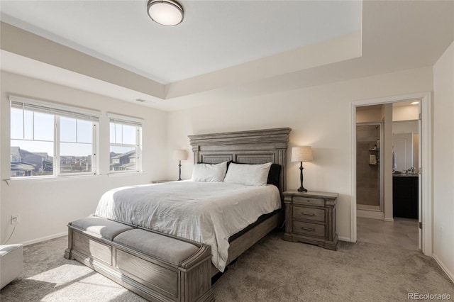 carpeted bedroom with baseboards and a tray ceiling