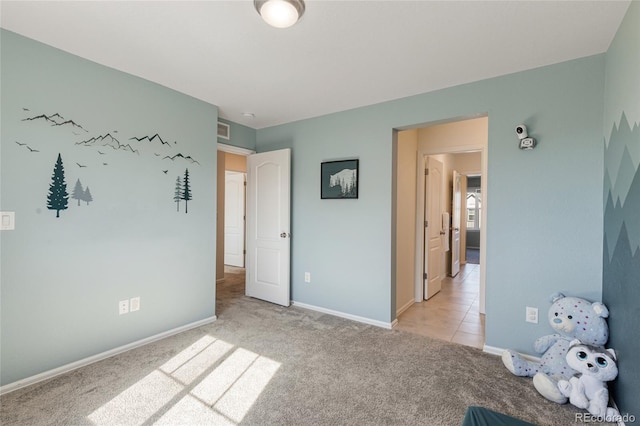 unfurnished bedroom featuring visible vents, light carpet, and baseboards