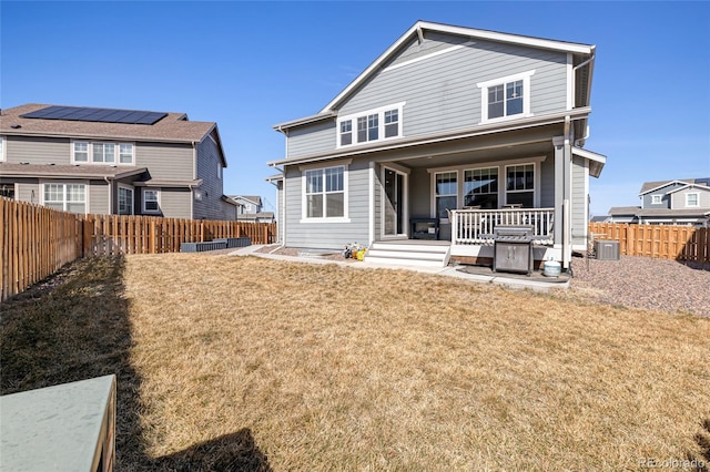 rear view of property featuring central air condition unit, a lawn, a porch, and a fenced backyard