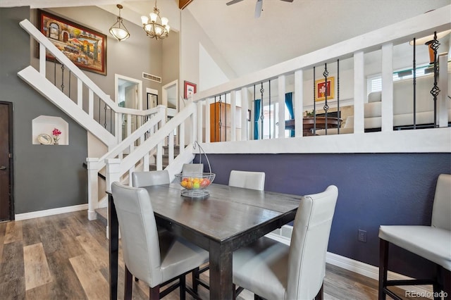 dining room with vaulted ceiling with beams, hardwood / wood-style flooring, and an inviting chandelier