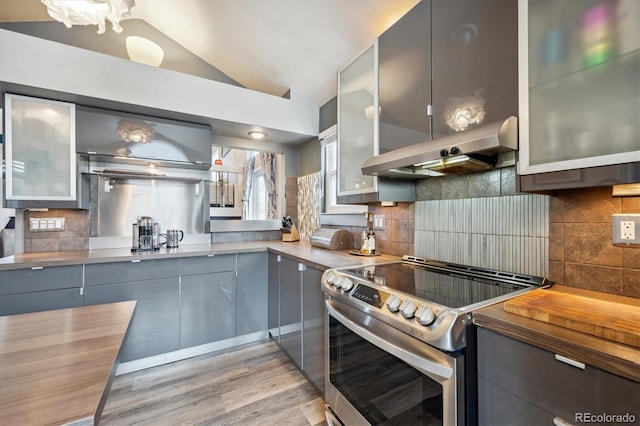 kitchen with backsplash, electric stove, extractor fan, and vaulted ceiling