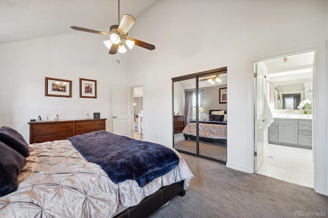 carpeted bedroom with ensuite bath, ceiling fan, high vaulted ceiling, multiple windows, and a closet