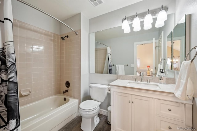 full bathroom with vanity, wood-type flooring, tiled shower / bath combo, and toilet