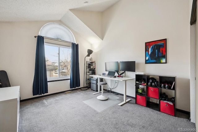 home office featuring a textured ceiling, carpet floors, and lofted ceiling