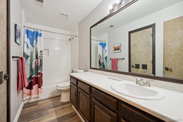 full bathroom with hardwood / wood-style floors, vanity, shower / bath combination with curtain, and toilet