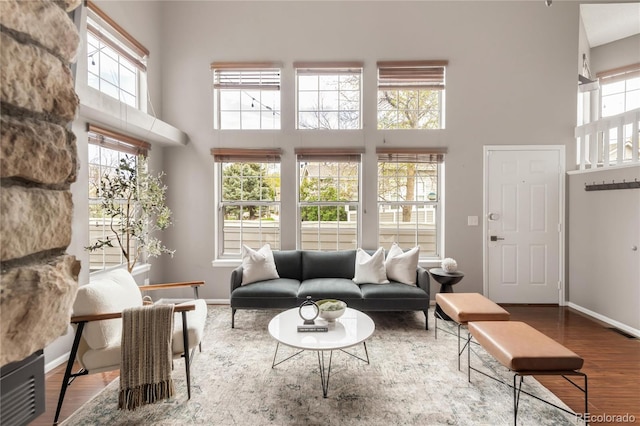6858 Zenobia St Unit 9, Westminster, CO 80030 - living room featuring a towering ceiling, plenty of natural light, wood finished floors, and baseboards