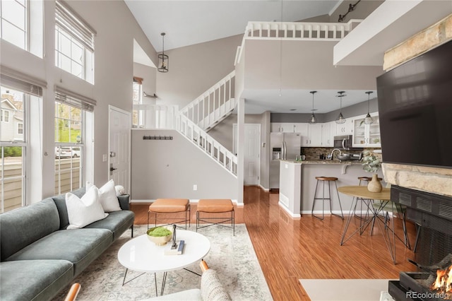 6858 Zenobia St Unit 9, Westminster, CO 80030 - living area featuring high vaulted ceiling, wood finished floors, stairs, and baseboards