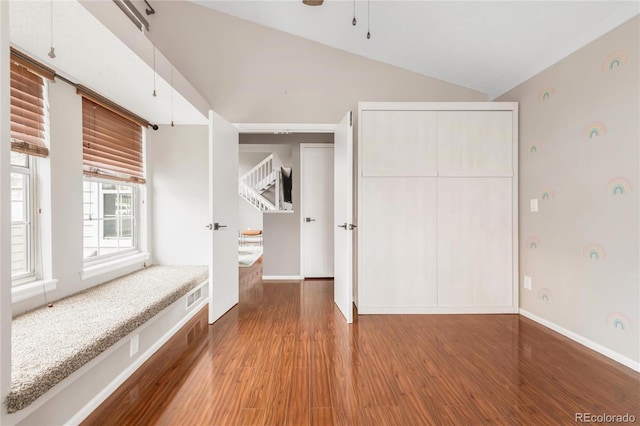 6858 Zenobia St Unit 9, Westminster, CO 80030 - unfurnished bedroom featuring wood finished floors, vaulted ceiling, baseboards, and a closet