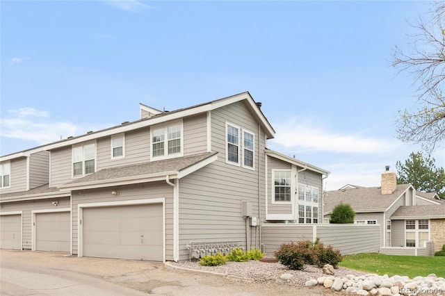 6858 Zenobia St Unit 9, Westminster, CO 80030 - view of property exterior featuring an attached garage, fence, and concrete driveway