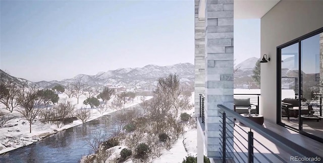 snow covered back of property featuring a mountain view