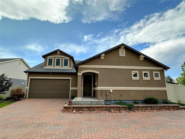 6765 Windbrook Ct, Colorado Springs, CO 80927 - view of front of house featuring stucco siding, decorative driveway, a garage, and a shingled roof