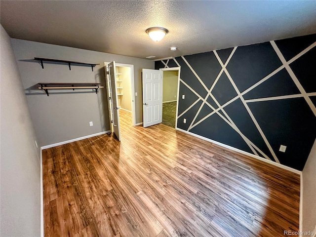 6765 Windbrook Ct, Colorado Springs, CO 80927 - unfurnished bedroom featuring wood finished floors and a textured ceiling