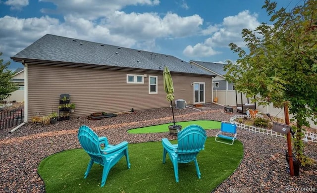 6765 Windbrook Ct, Colorado Springs, CO 80927 - rear view of property featuring an area to practice putting, a fenced backyard, and roof with shingles