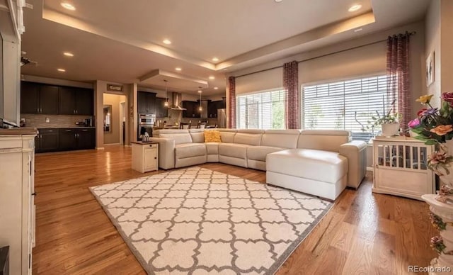 6765 Windbrook Ct, Colorado Springs, CO 80927 - living area featuring a raised ceiling, light wood-style flooring, and recessed lighting
