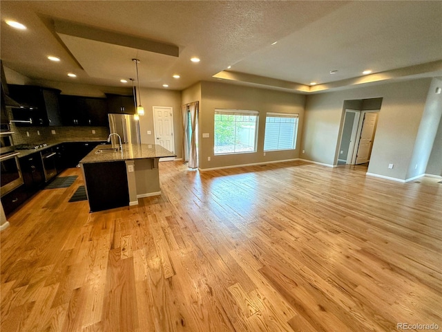 6765 Windbrook Ct, Colorado Springs, CO 80927 - kitchen with open floor plan, stainless steel appliances, dark cabinets, backsplash, and recessed lighting