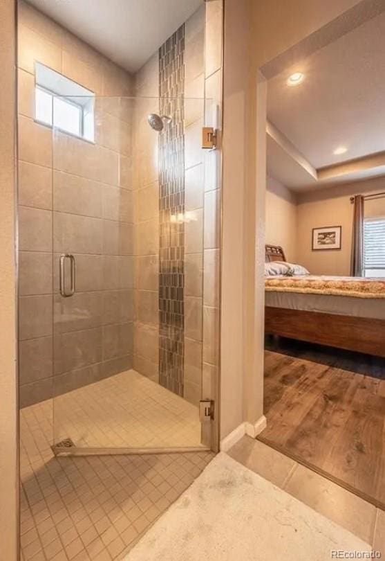 6765 Windbrook Ct, Colorado Springs, CO 80927 - bathroom with a stall shower, connected bathroom, tile patterned floors, and recessed lighting