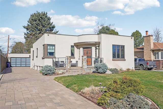 621 Kearney St, Denver, CO 80220 - view of front of house featuring a garage, a front yard, and stucco siding