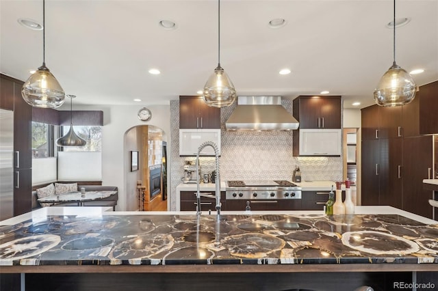 621 Kearney St, Denver, CO 80220 - kitchen featuring wall chimney range hood, arched walkways, decorative backsplash, and recessed lighting