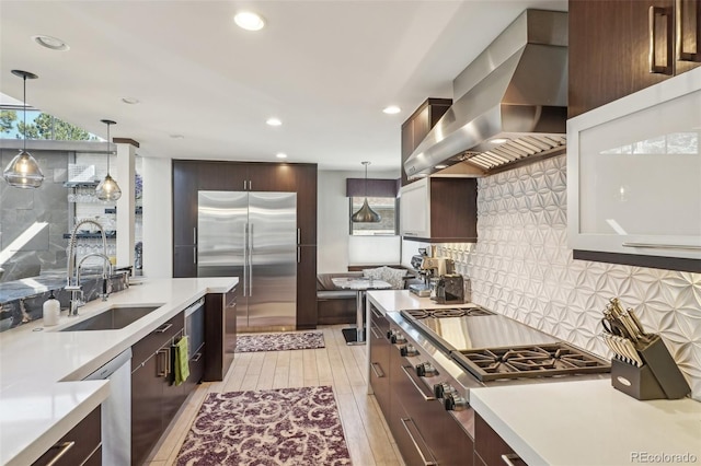 621 Kearney St, Denver, CO 80220 - kitchen featuring light countertops, appliances with stainless steel finishes, a sink, and wall chimney exhaust hood
