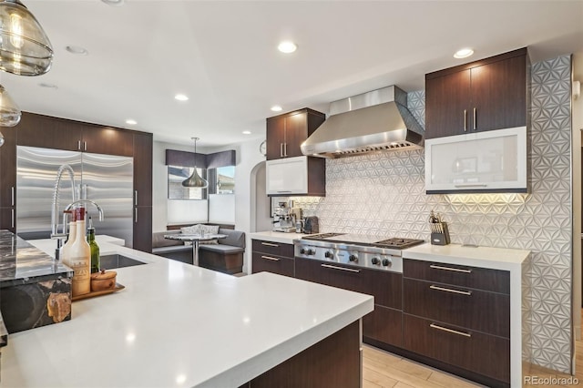 621 Kearney St, Denver, CO 80220 - kitchen featuring decorative backsplash, pendant lighting, appliances with stainless steel finishes, light countertops, and wall chimney exhaust hood