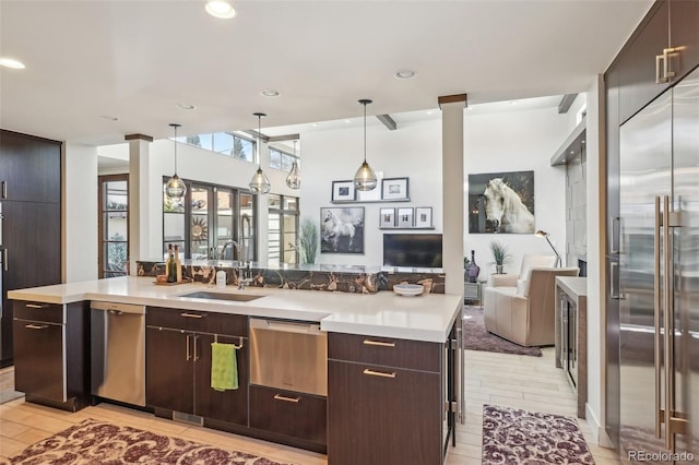 621 Kearney St, Denver, CO 80220 - kitchen with dark brown cabinets, open floor plan, light countertops, decorative light fixtures, and stainless steel appliances