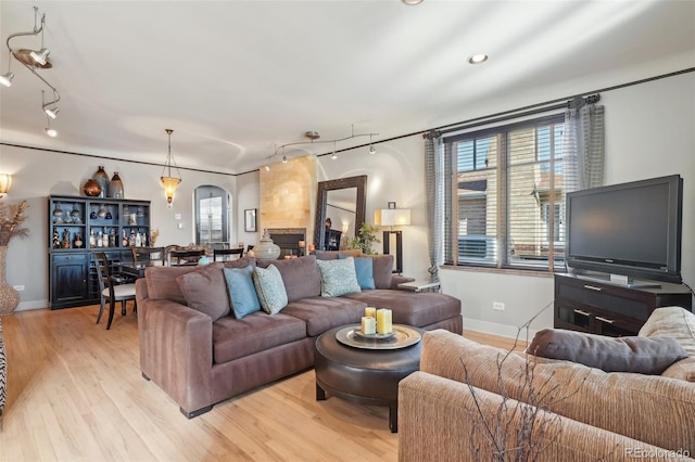 621 Kearney St, Denver, CO 80220 - living room with arched walkways, baseboards, rail lighting, and light wood-style flooring