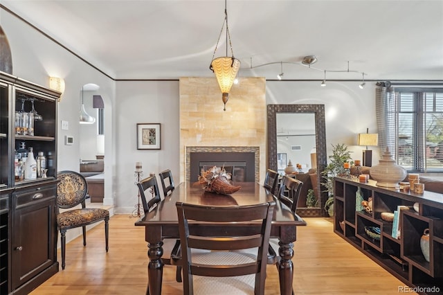 621 Kearney St, Denver, CO 80220 - dining space with light wood-type flooring, arched walkways, and a fireplace