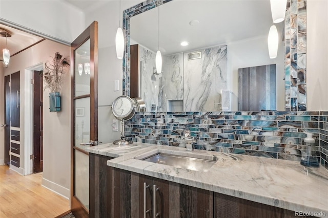621 Kearney St, Denver, CO 80220 - bathroom with baseboards, decorative backsplash, wood finished floors, and vanity
