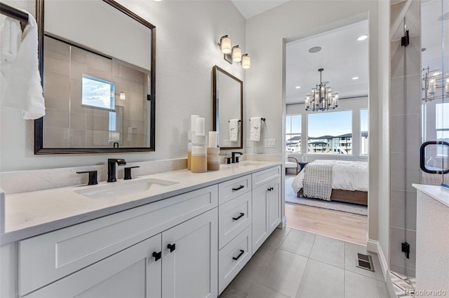 bathroom featuring vanity, a chandelier, a shower with shower door, and hardwood / wood-style flooring