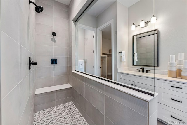 bathroom featuring a tile shower and vanity