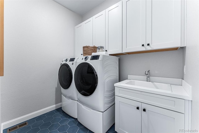 laundry room featuring washer and clothes dryer, cabinets, dark tile patterned flooring, and sink