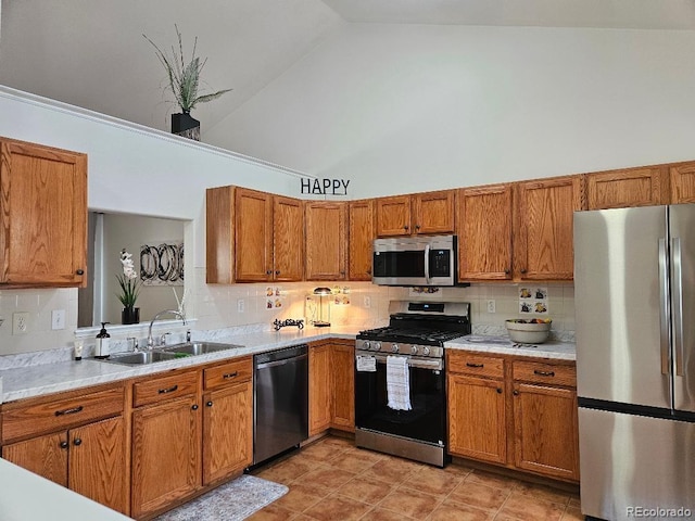 808 Idalia St, Aurora, CO 80011 - kitchen featuring appliances with stainless steel finishes, a sink, high vaulted ceiling, brown cabinetry, and light countertops