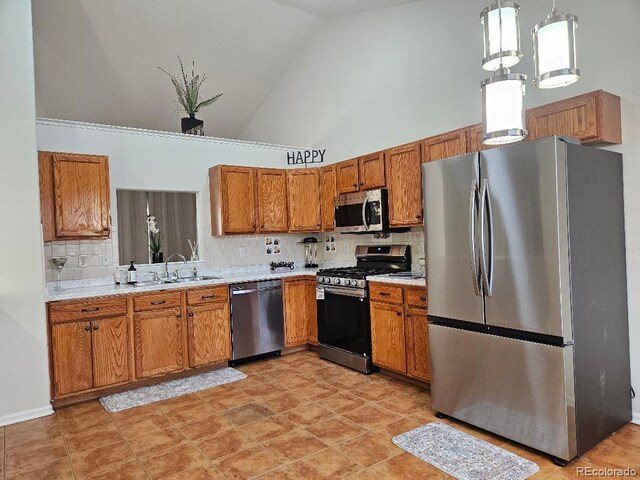 808 Idalia St, Aurora, CO 80011 - kitchen with appliances with stainless steel finishes, a sink, high vaulted ceiling, brown cabinetry, and light countertops