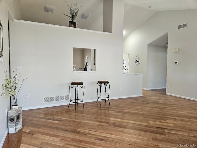 808 Idalia St, Aurora, CO 80011 - unfurnished living room featuring wood finished floors, baseboards, and vaulted ceiling