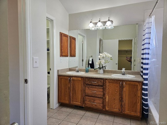808 Idalia St, Aurora, CO 80011 - bathroom featuring tile patterned flooring, double vanity, toilet, and shower / bath combo with shower curtain