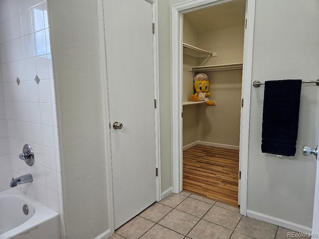 808 Idalia St, Aurora, CO 80011 - full bathroom with tile patterned floors, a spacious closet, shower / washtub combination, and baseboards