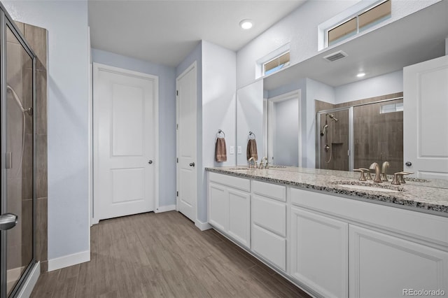 15604 Xenia Way, Brighton, CO 80602 - full bath featuring a stall shower, double vanity, wood finished floors, baseboards, and recessed lighting