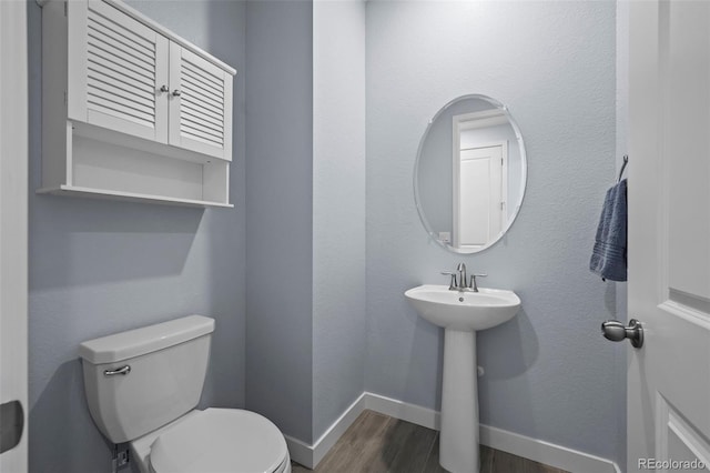 15604 Xenia Way, Brighton, CO 80602 - bathroom featuring wood finished floors, toilet, baseboards, and a sink